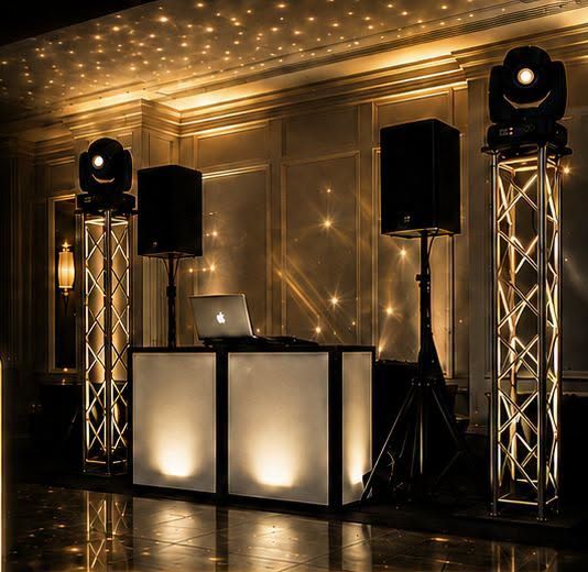 DJ booth with truss lighting and speakers set up in a ballroom